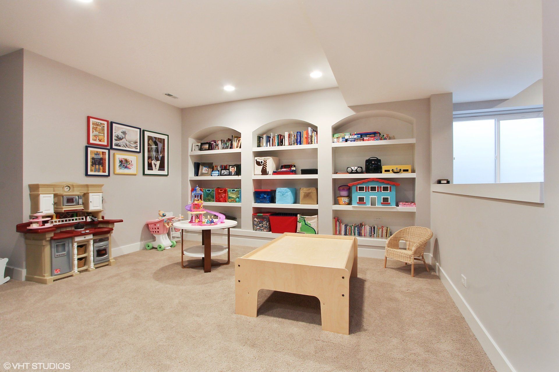 A play room with a table and shelves filled with toys