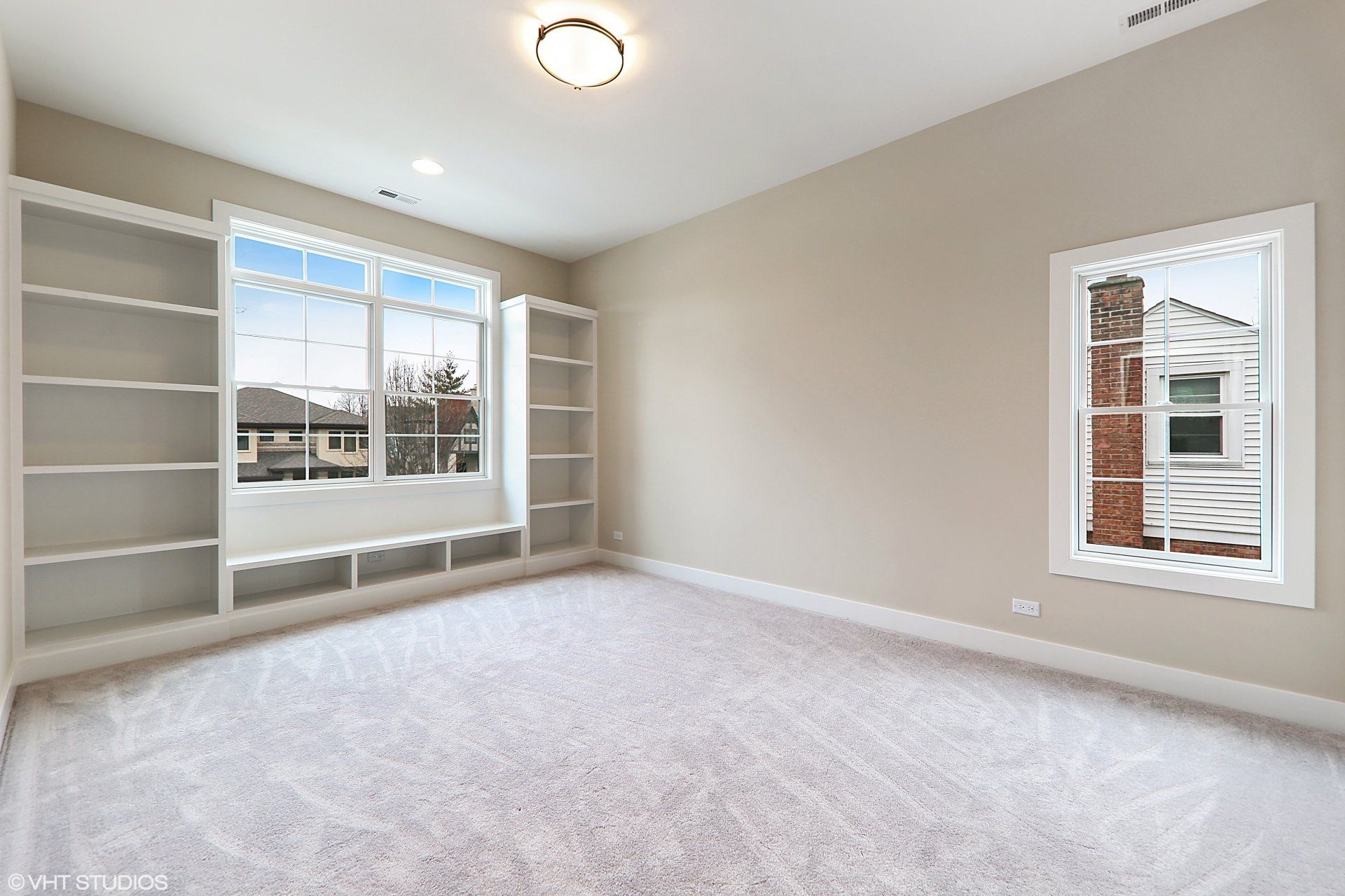 An empty room with a lot of windows and shelves.
