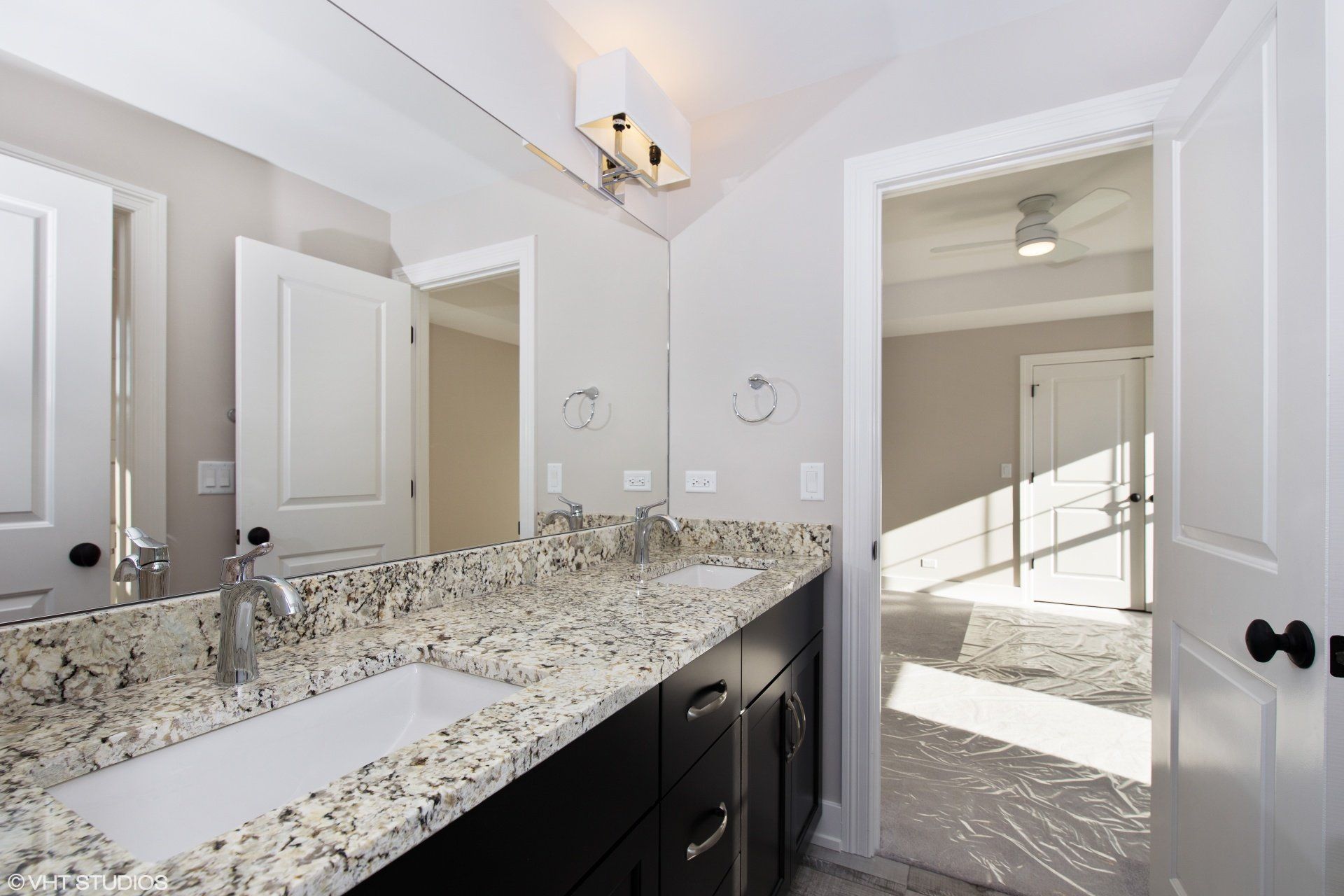 A bathroom with two sinks and a large mirror
