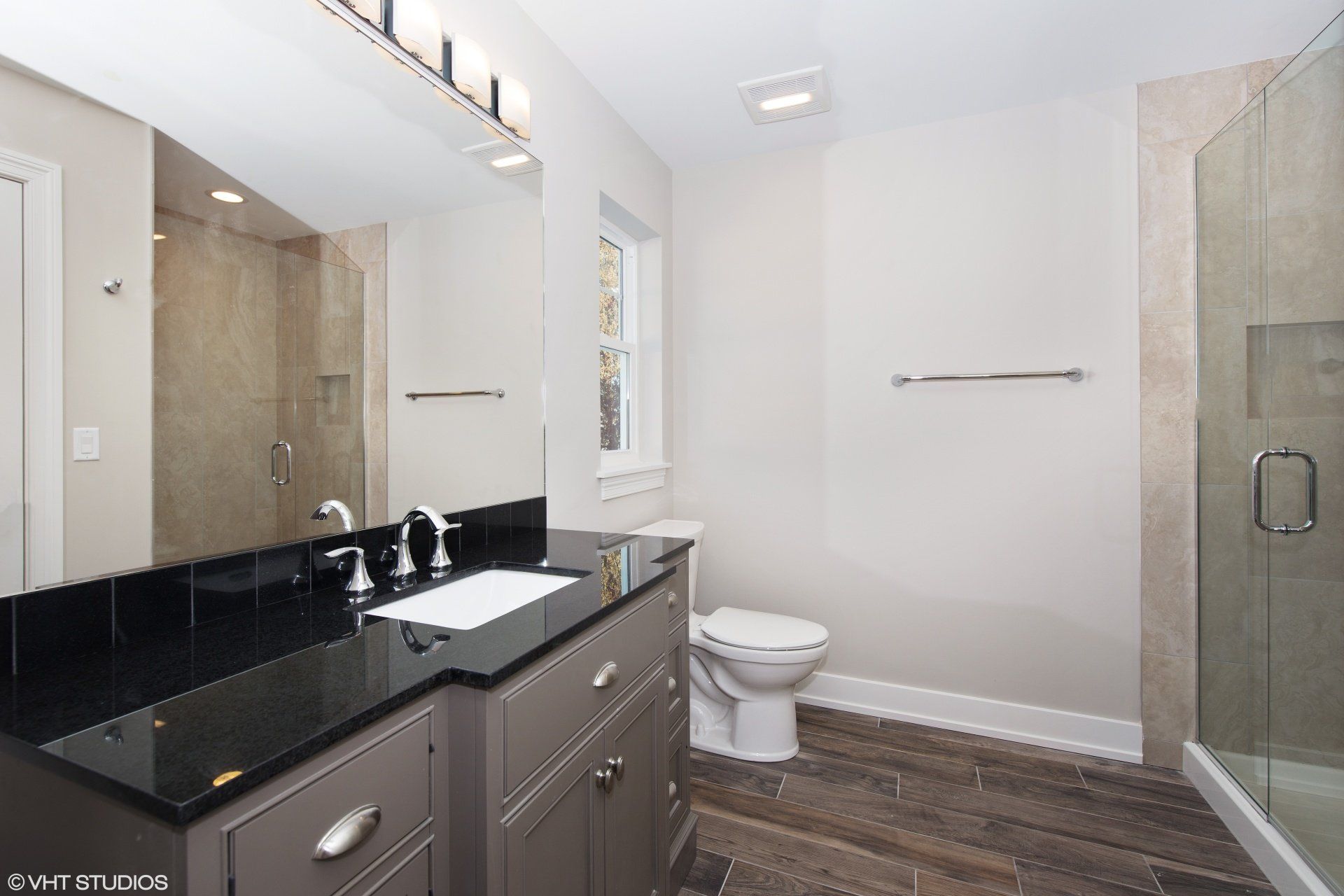 A bathroom with a toilet a sink and a mirror