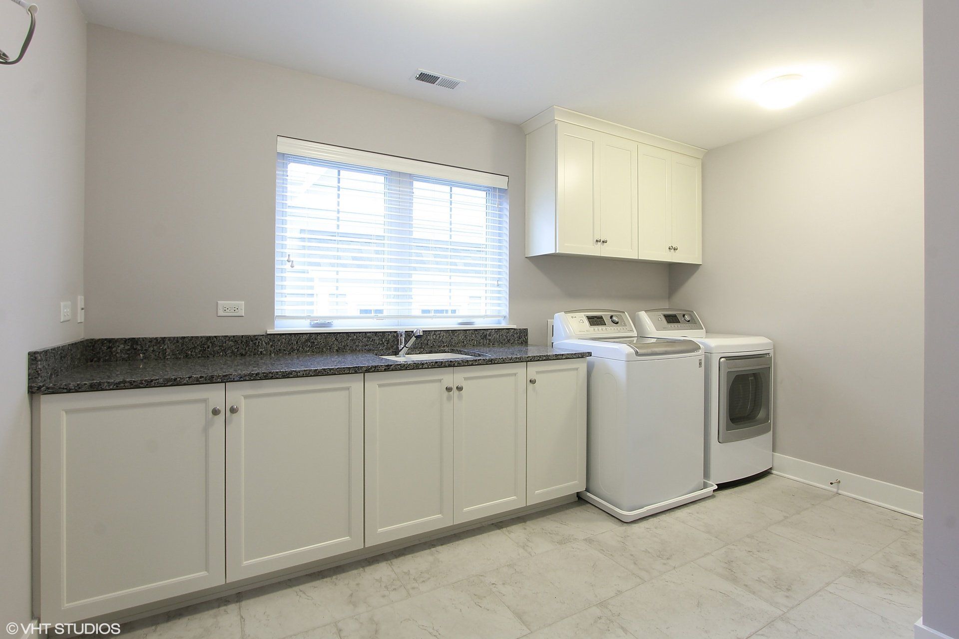 A laundry room with a washer and dryer and a sink.