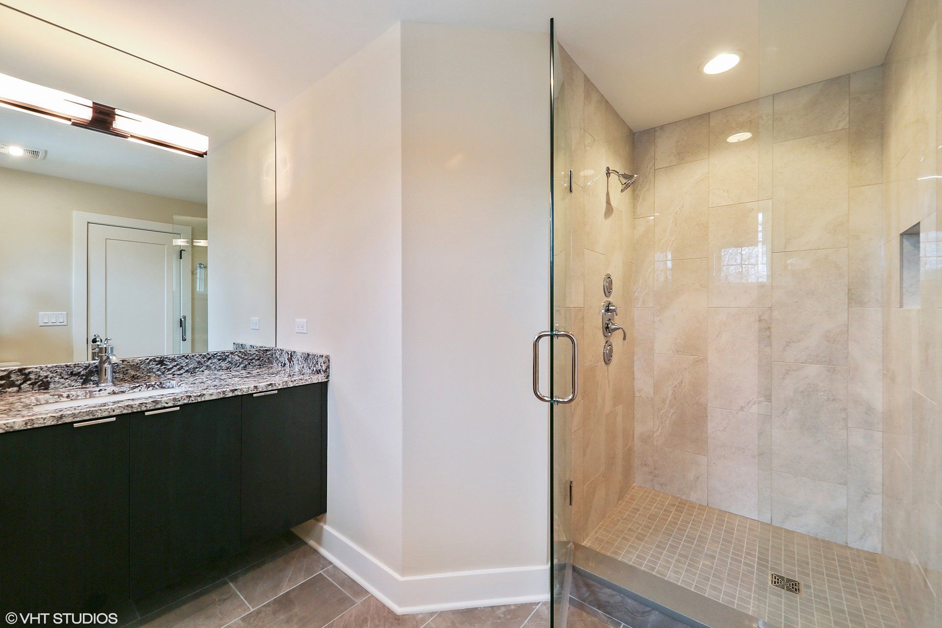 A bathroom with a walk in shower and a sink.
