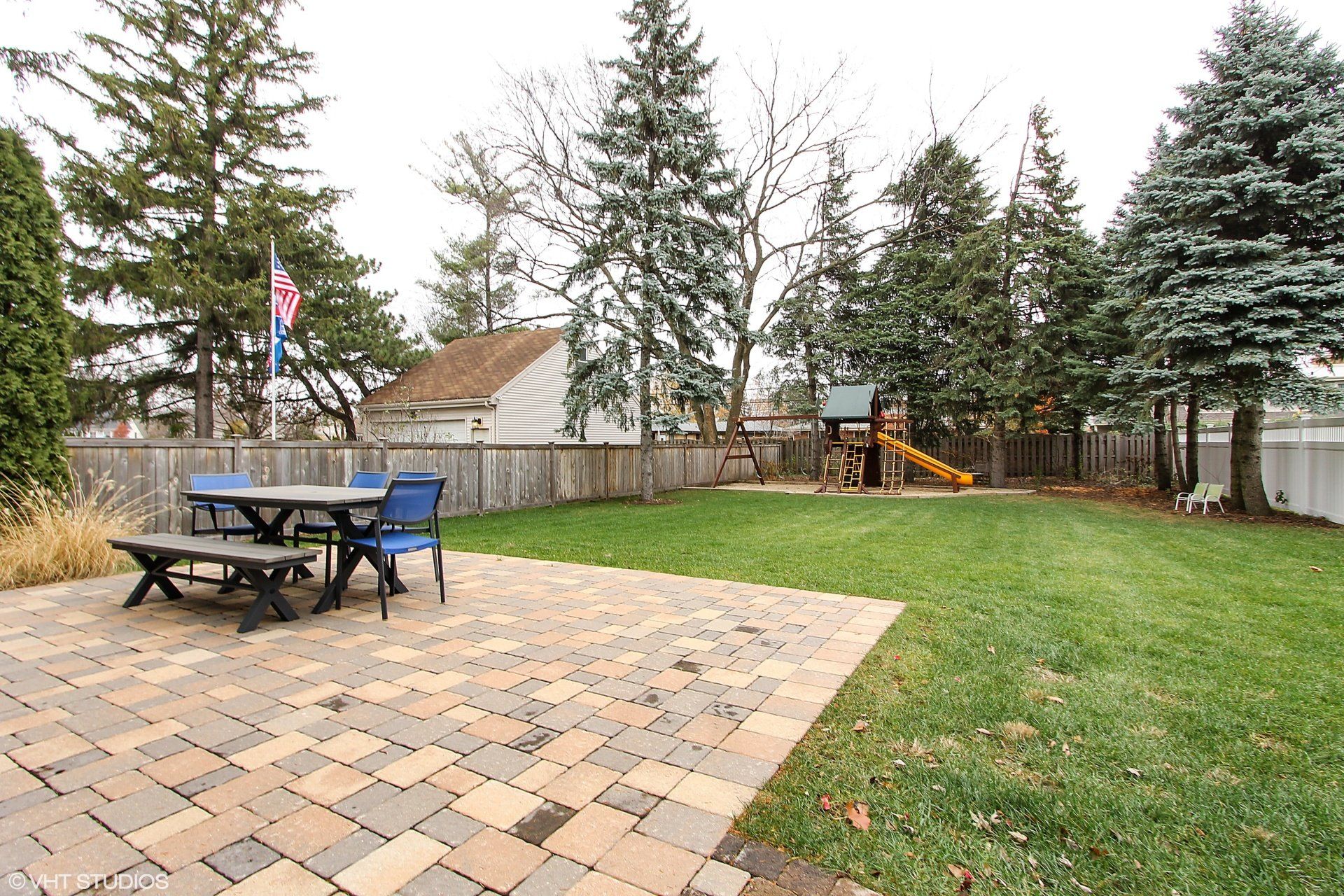 A backyard with a picnic table and chairs