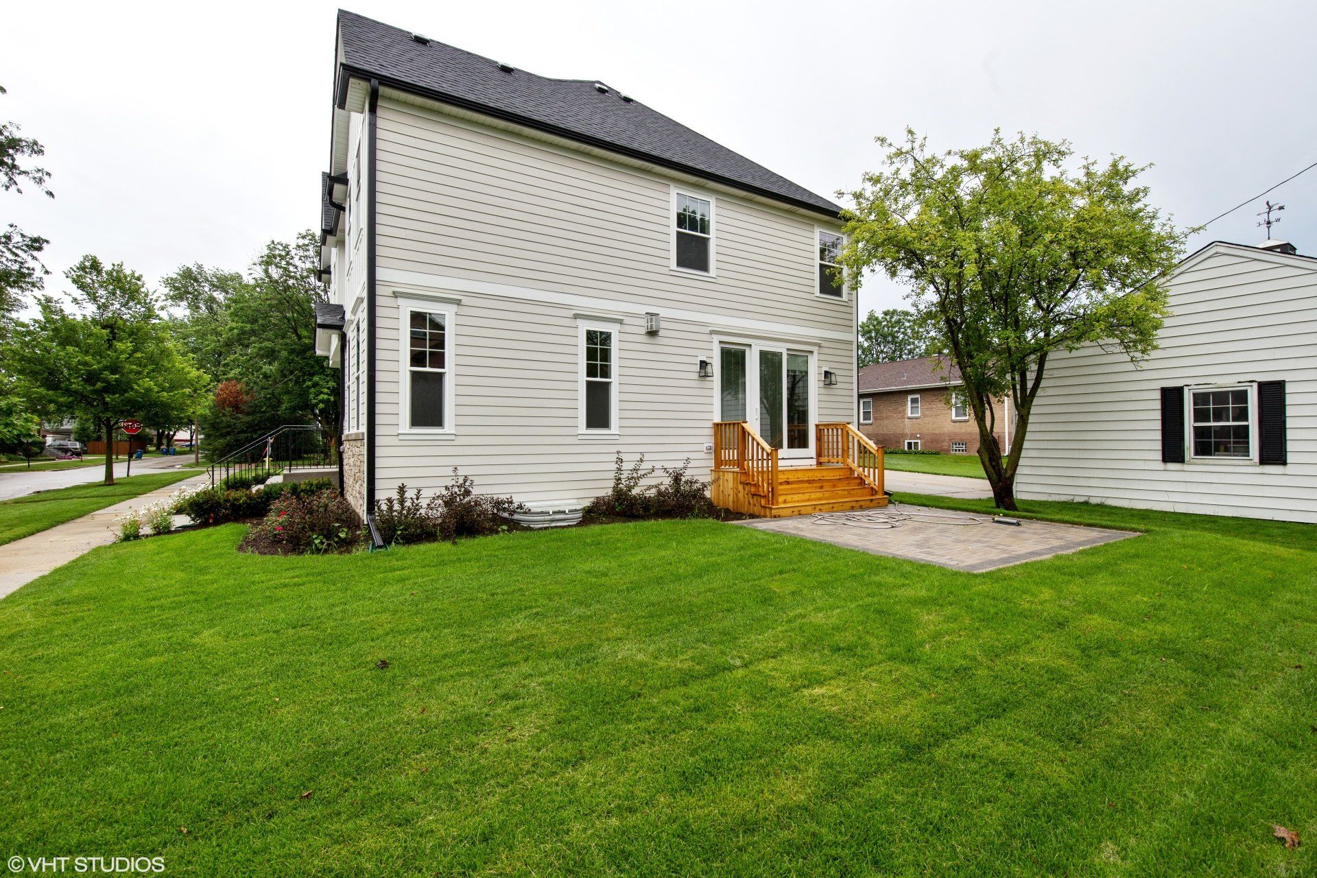 A white house with a large lawn in front of it.