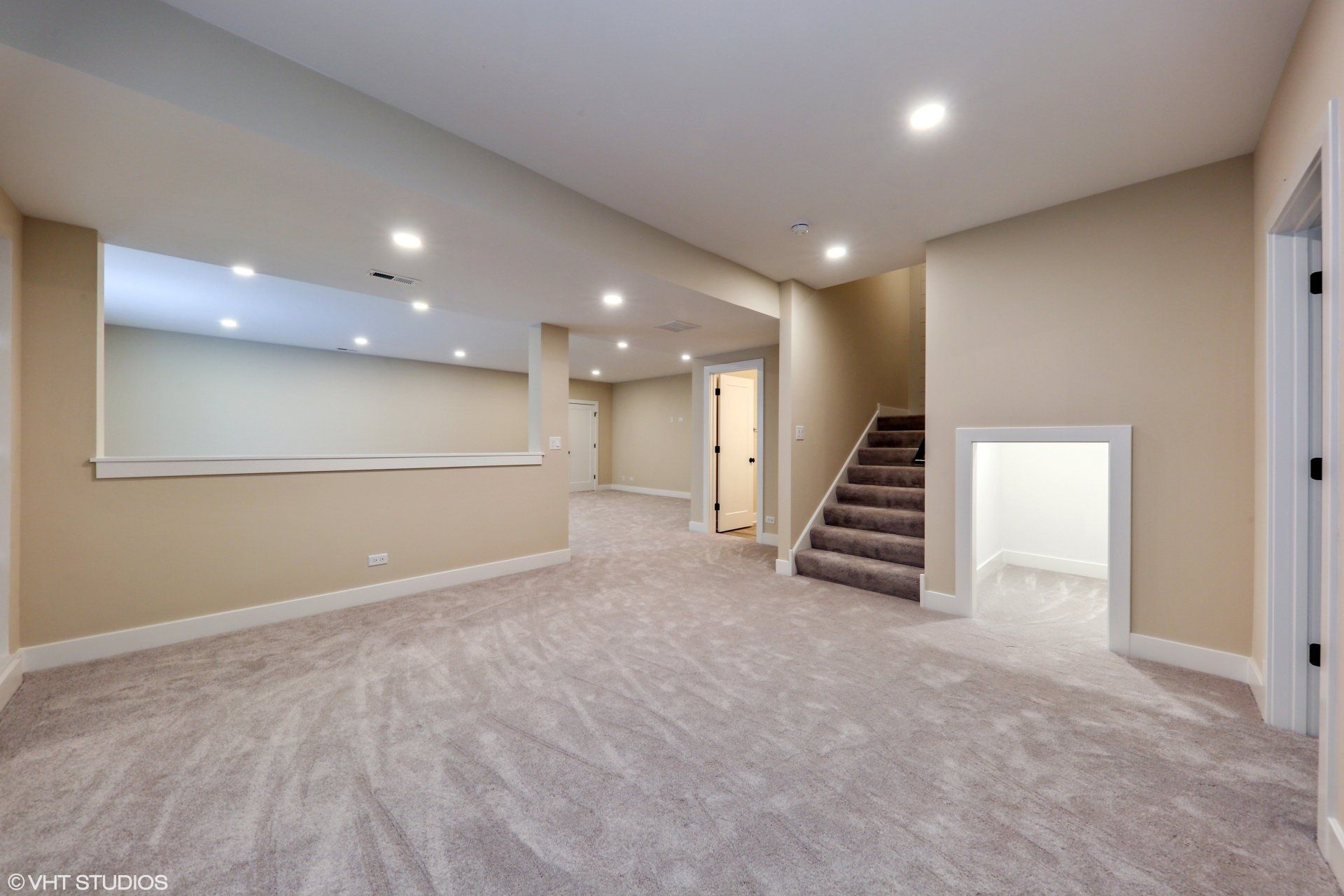 An empty basement with stairs leading up to the second floor.