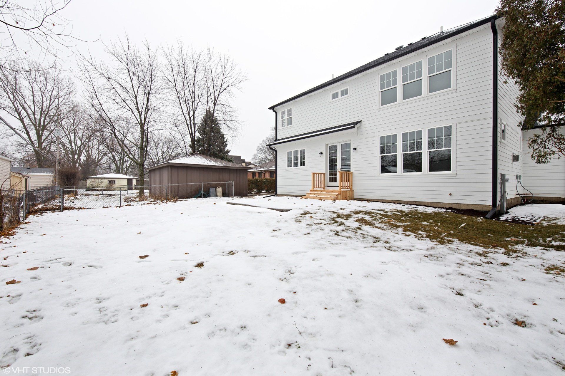 A large white house with a lot of windows is covered in snow.
