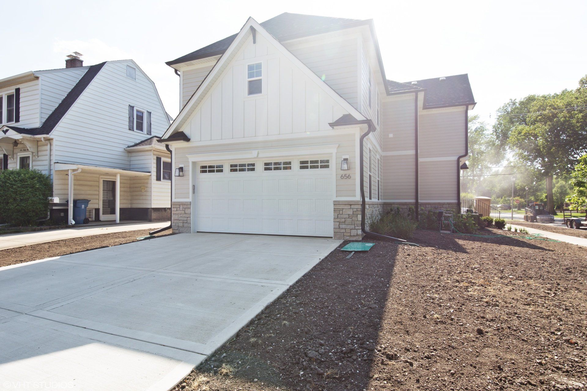 A white house with a garage and a driveway in front of it.
