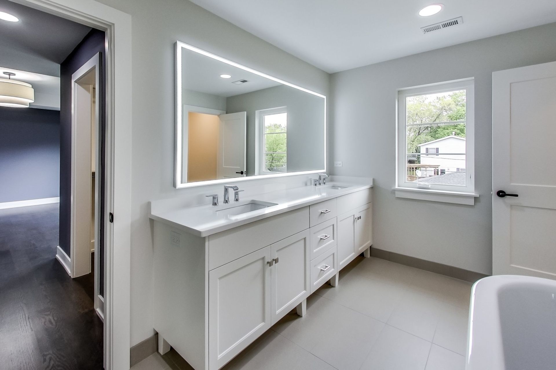 A bathroom with two sinks and a large mirror.