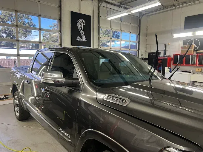 Pickup truck inside a garage with auto window tinting, showing the finished darkened windows for privacy and sun protection.