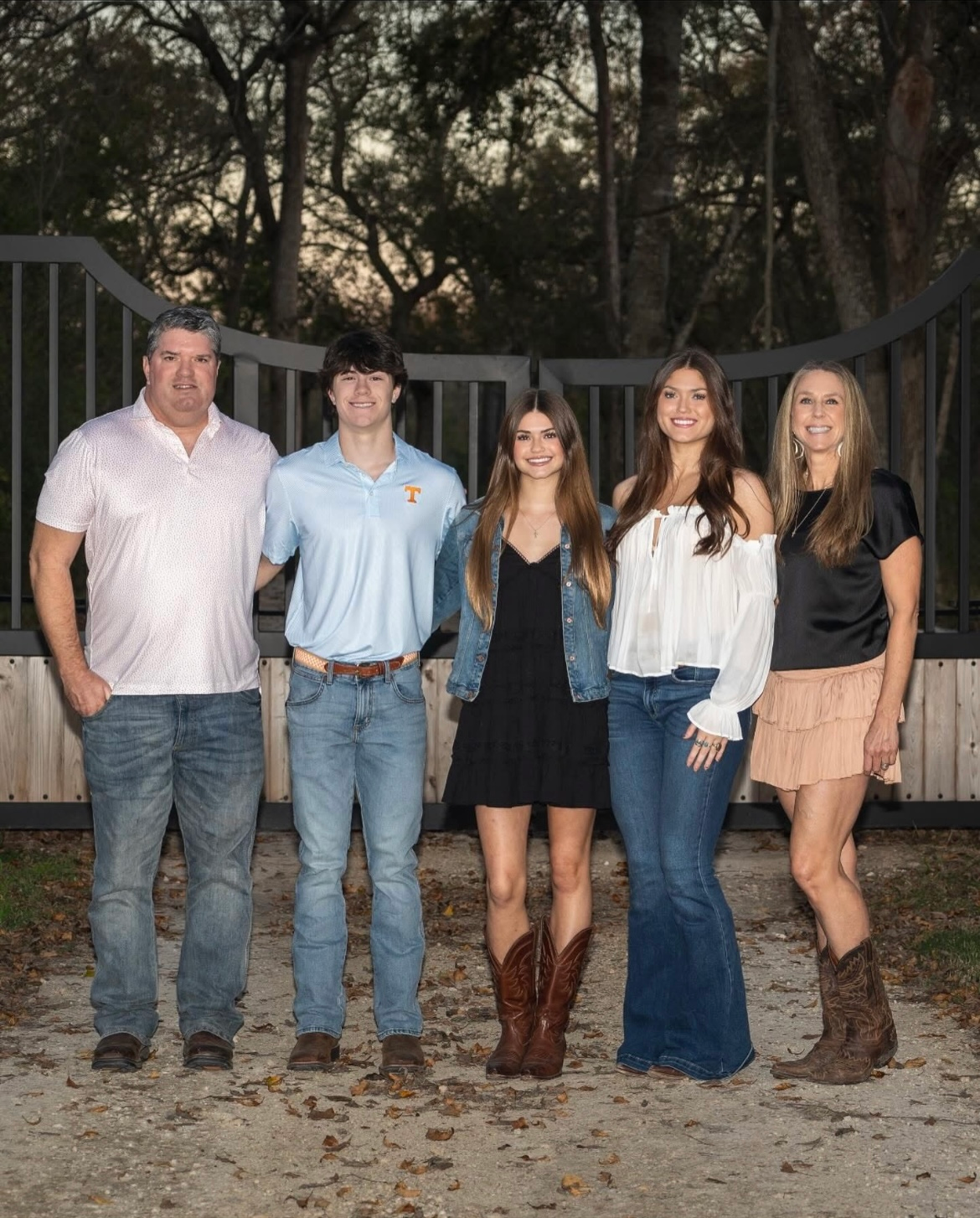 Contractor hands installing bitumen roof shingles using hammer in nails.