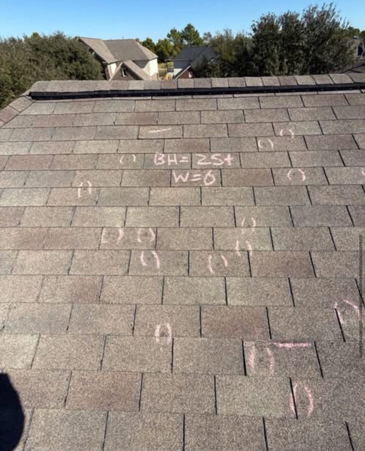 Contractor On Ladder Figuring Hail Damage Reairs To Roof