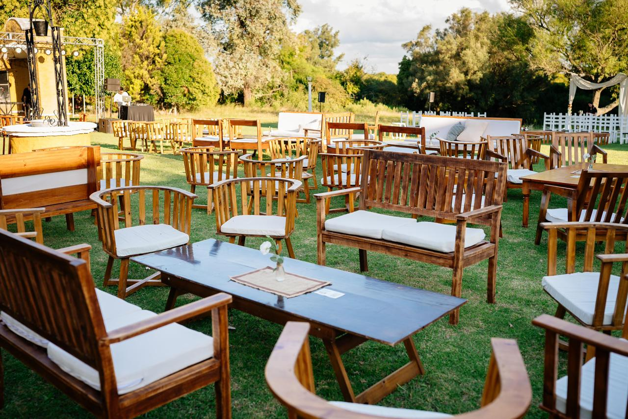 Zona de estar al aire libre sobre un césped con bancos de madera