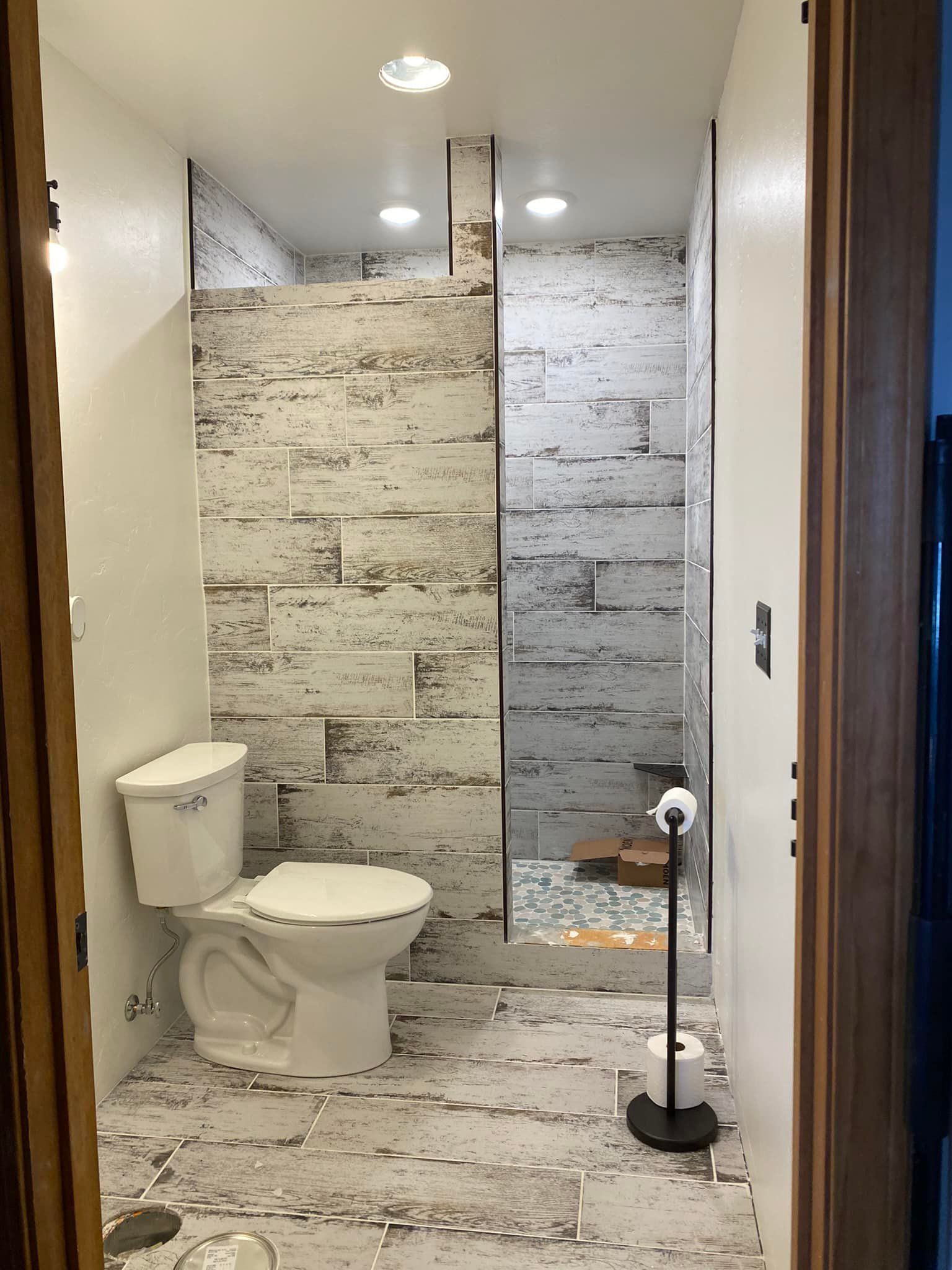 A bathroom with a toilet and a walk in shower.