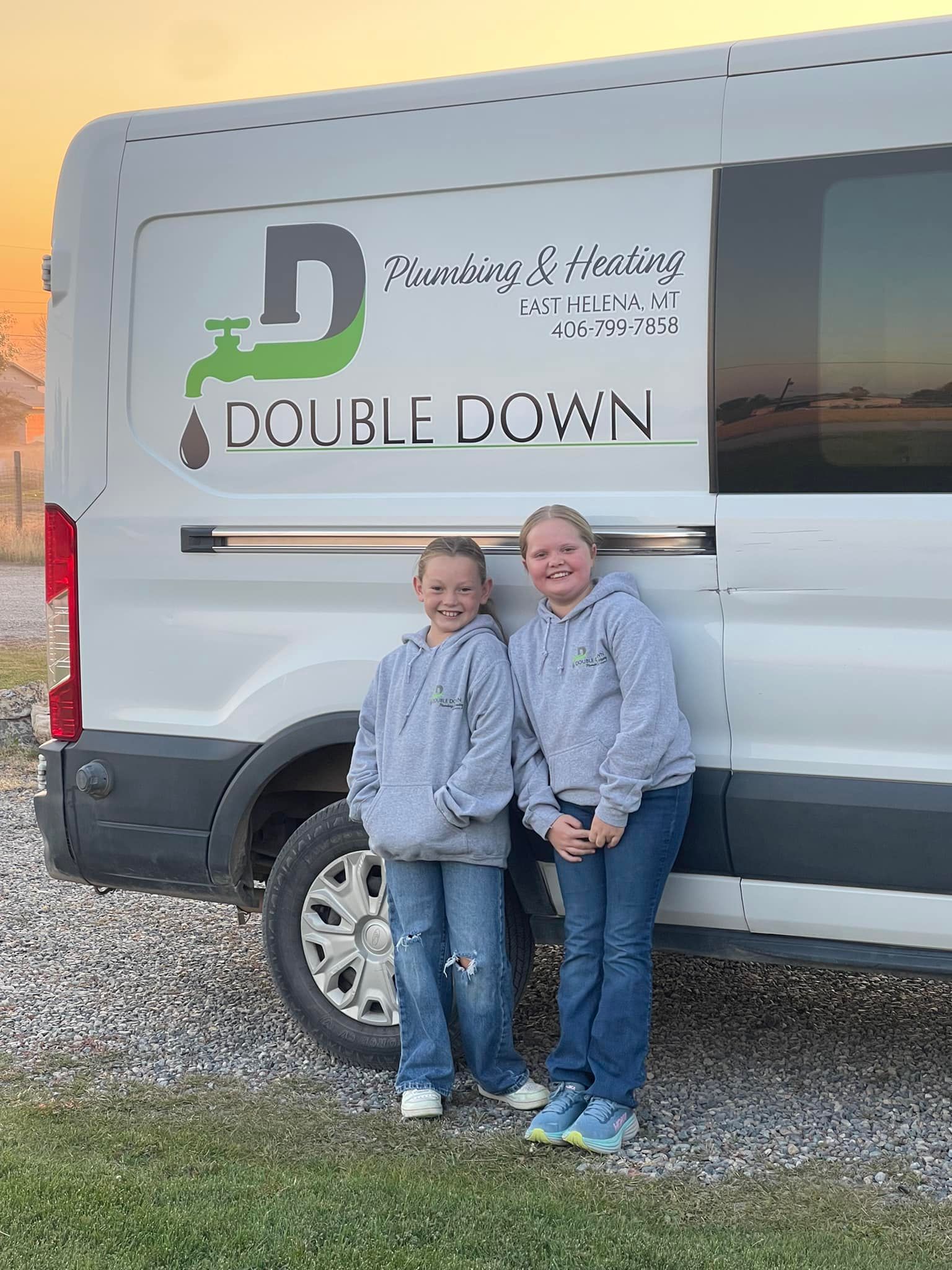 Two girls are standing next to a white van.