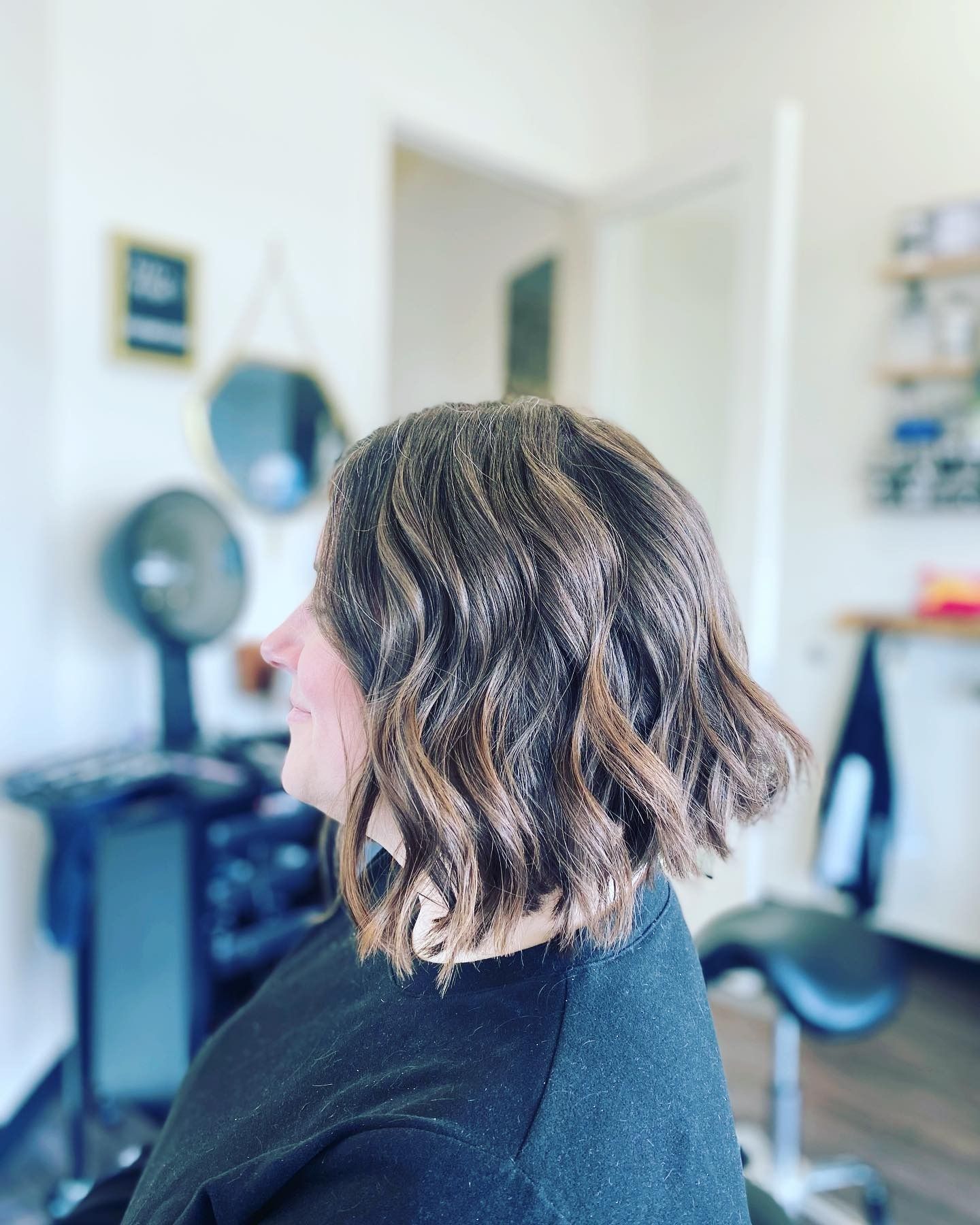 A woman is getting her hair cut in a salon.