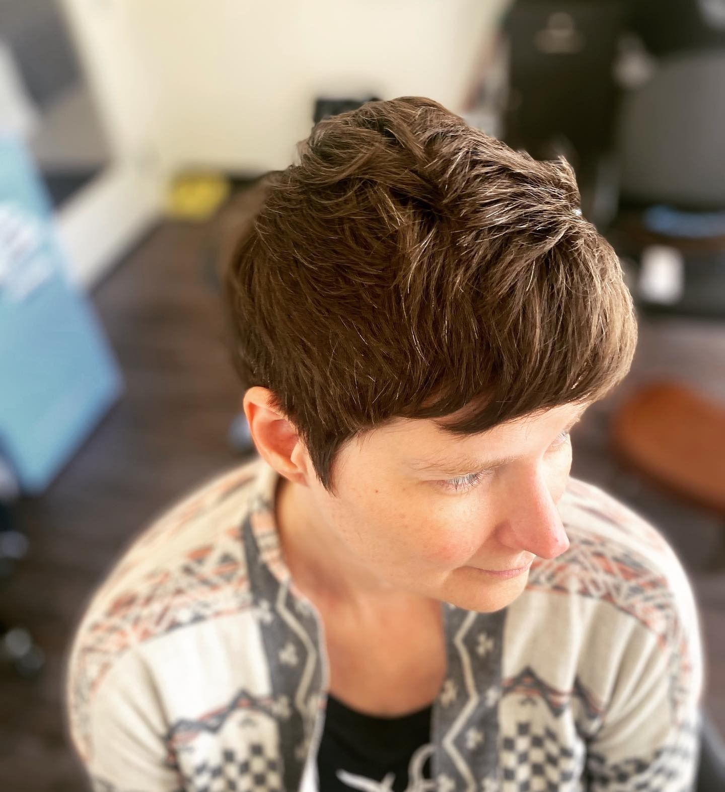 A woman with short brown hair is wearing a sweater.