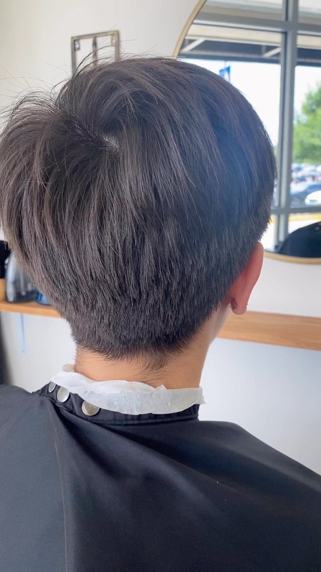 A man is getting his hair cut at a barber shop.