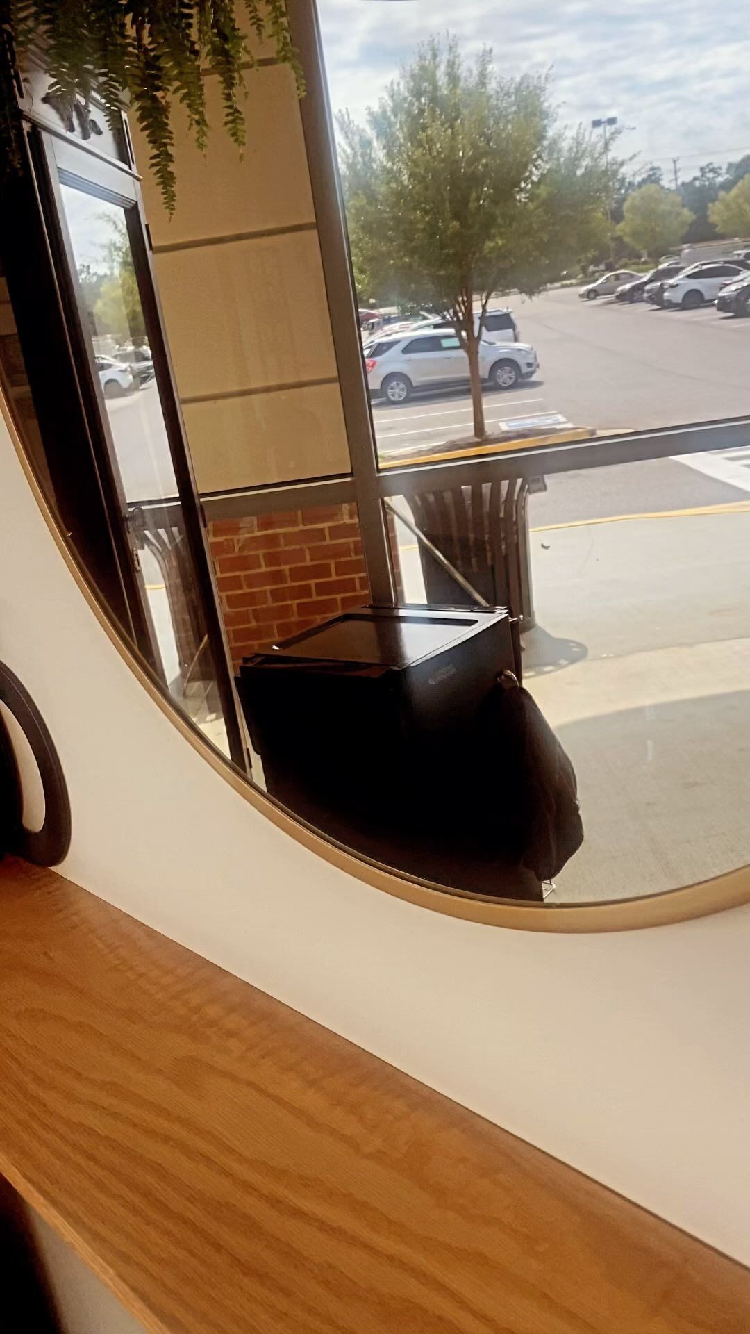 A mirror with a reflection of a parking lot in it.