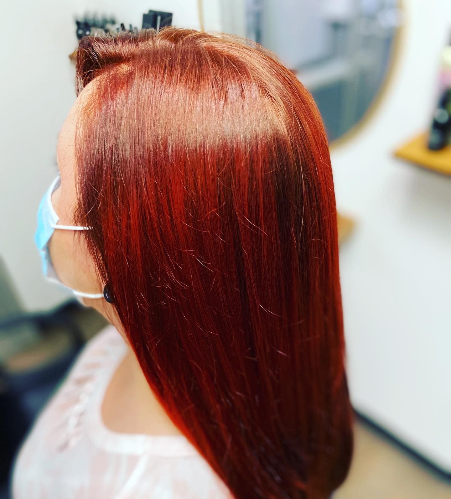 A woman with red hair is wearing a face mask.