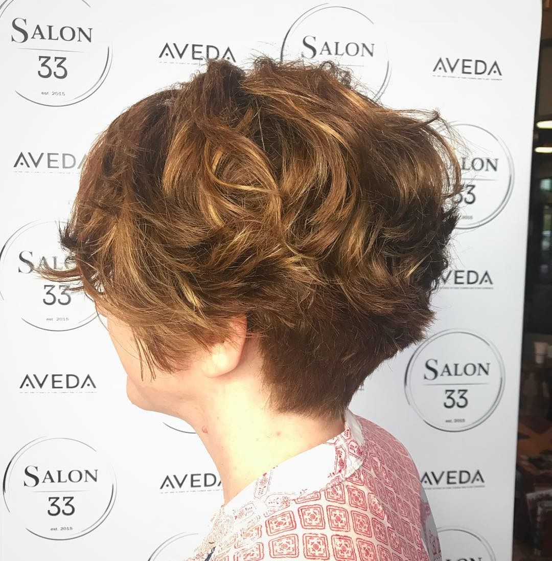 A woman is standing in front of a sign that says salon 33