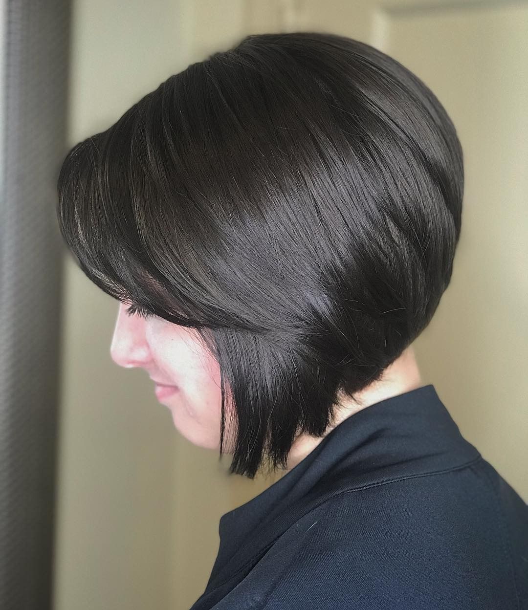 A woman with short dark hair is wearing a black shirt