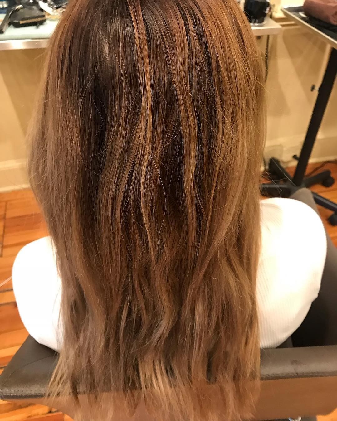 A woman with long brown hair is sitting in a chair