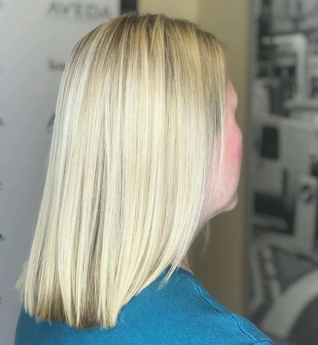 A woman with blonde hair is wearing a blue sweater.