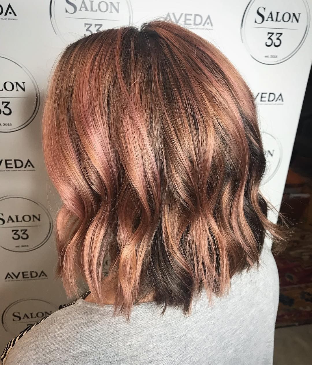 A woman is standing in front of a sign that says salon 33.