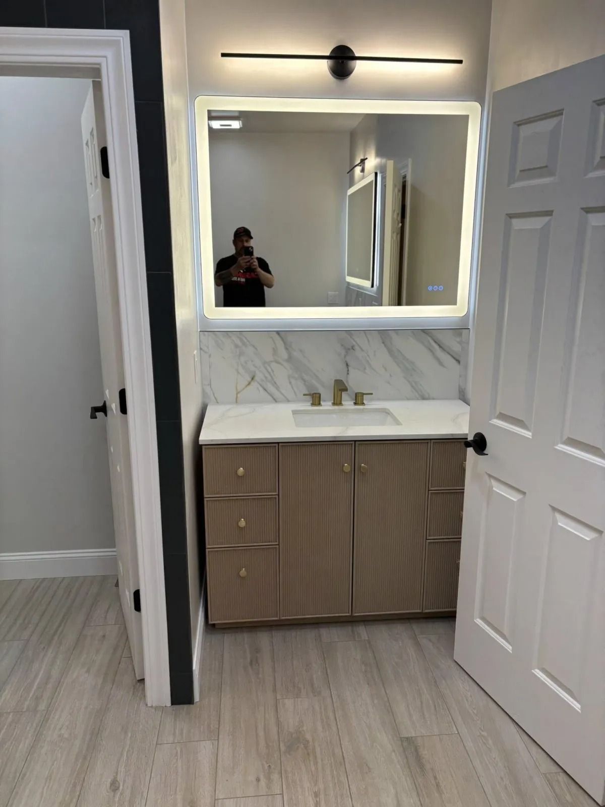 Bathroom with illuminated mirror above a vanity.