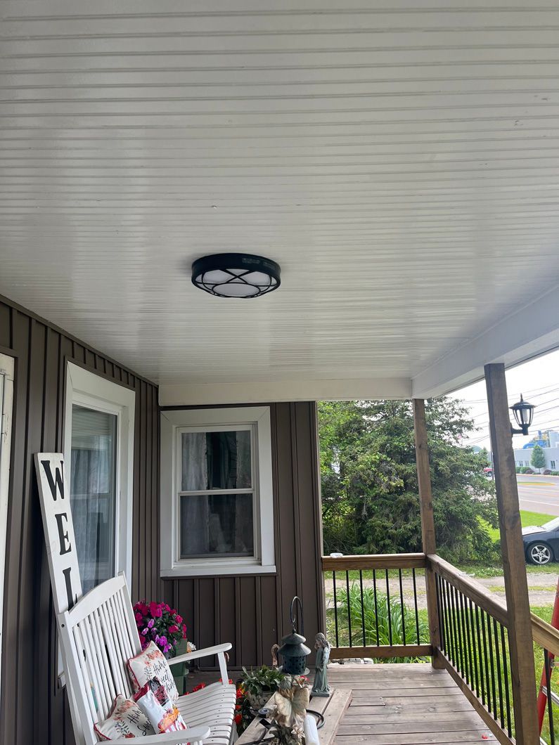 Porch with white ceiling and walls, bench, windows, and a porch light.