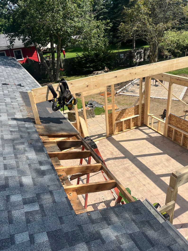 Construction site: Rooftop being modified, new wooden structure partially built.