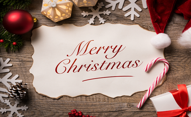 A merry christmas card with a candy cane and santa hat on a wooden table.