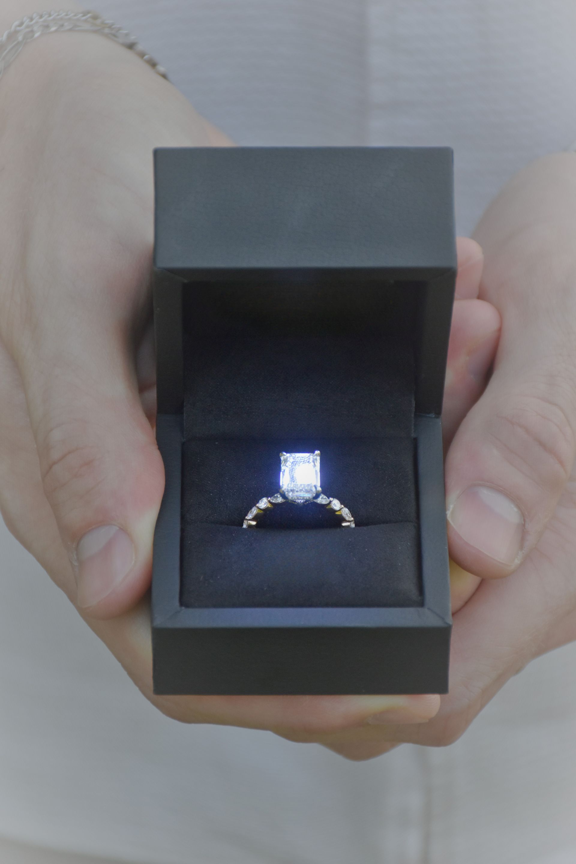 Red high heel shoe on white surface, illuminated by two studio lights.