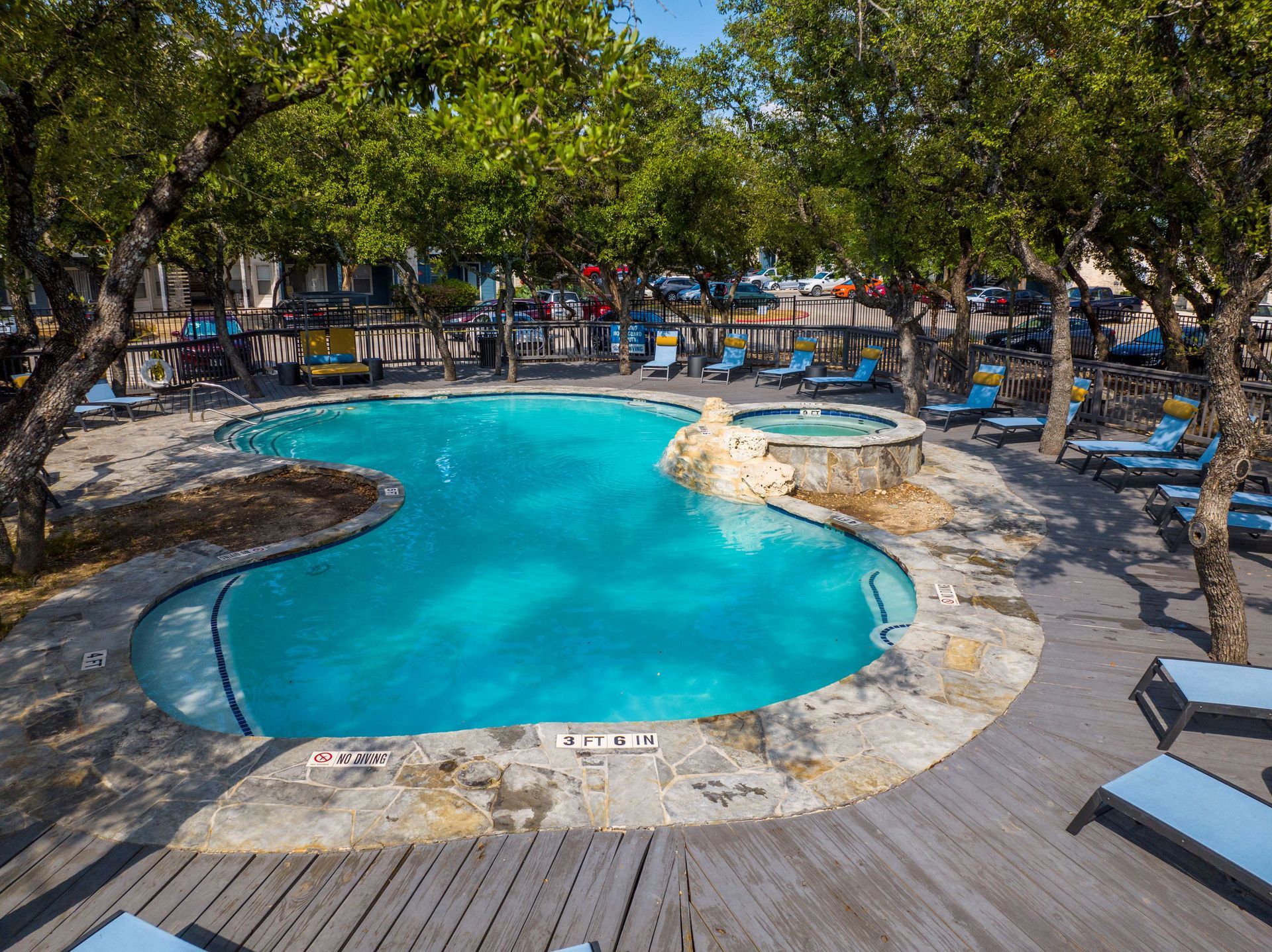A large swimming pool surrounded by trees and chairs at Allure at Shavano.
