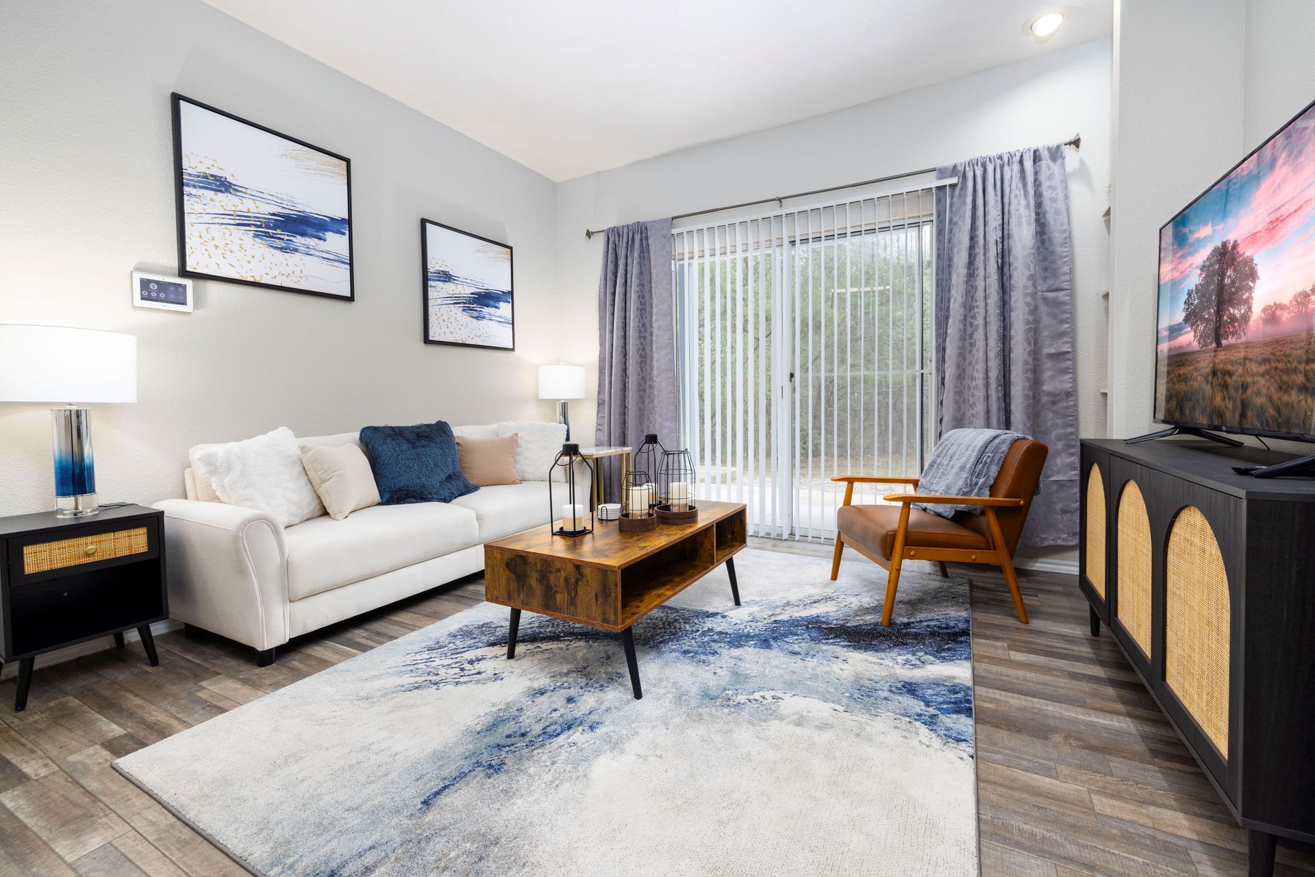 A living room with a couch , chairs , coffee table and television at Allure at Shavano.