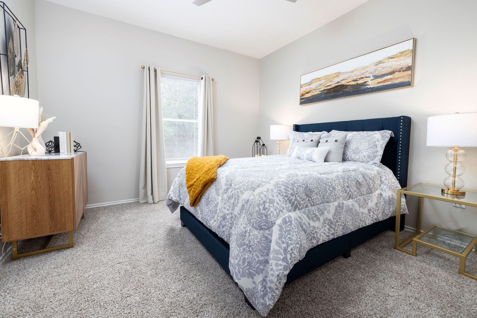 A bedroom with a bed , dresser , lamps , and a window at Allure at Shavano.