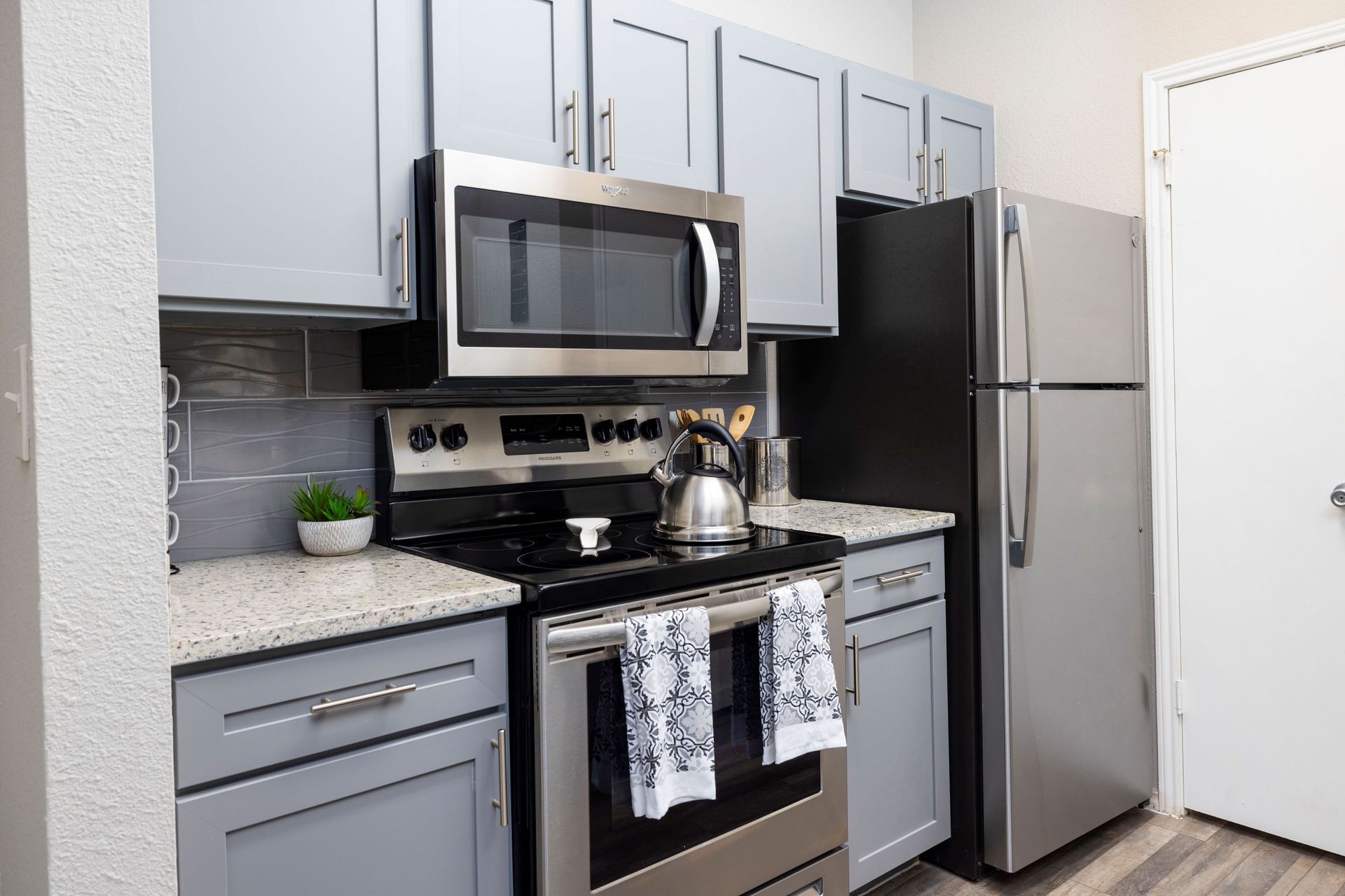 A kitchen with a stove , microwave , refrigerator and cabinets at Allure at Shavano.