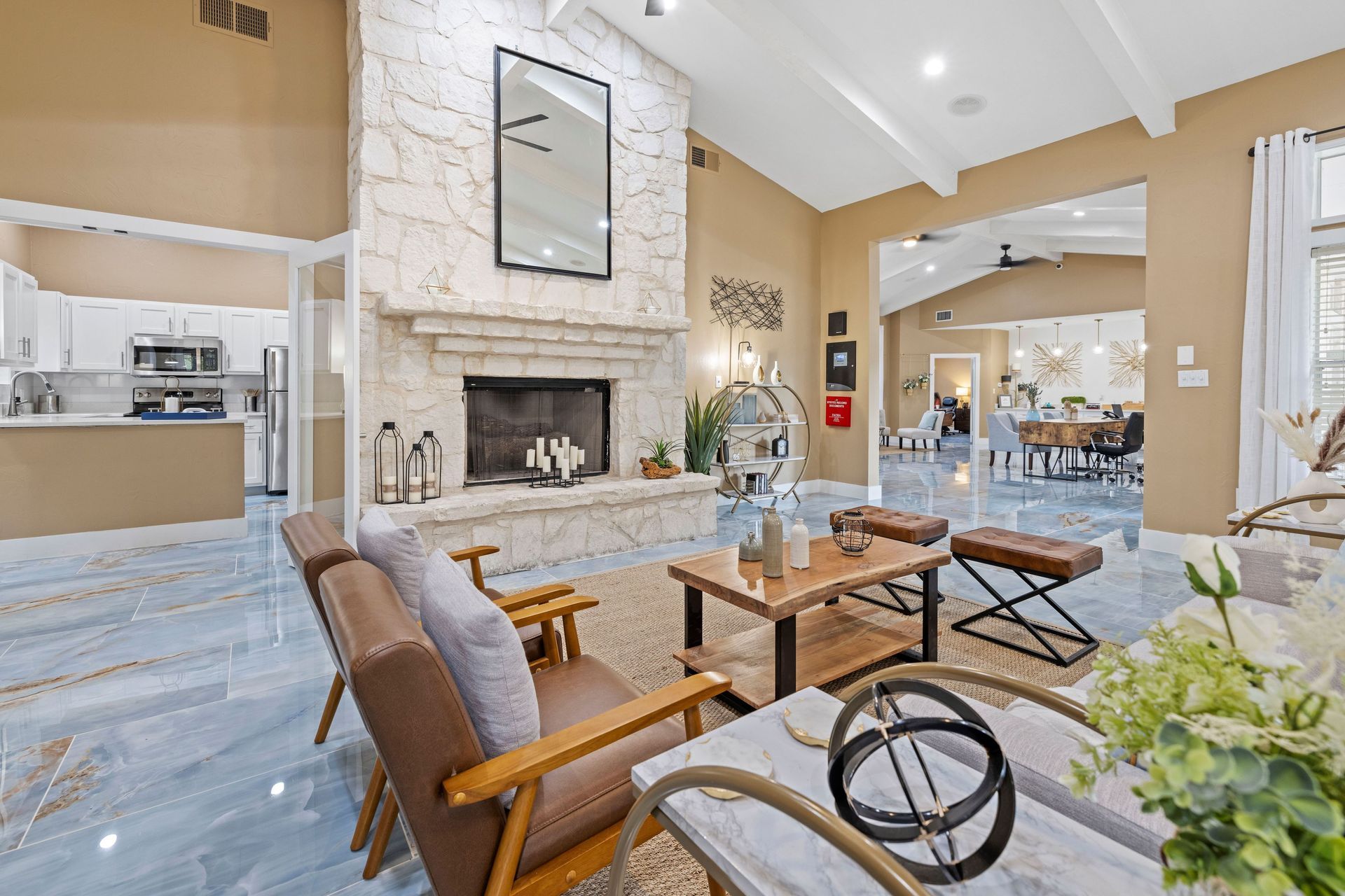 A living room with a fireplace , chairs , a table and a mirror at Allure at Shavano.