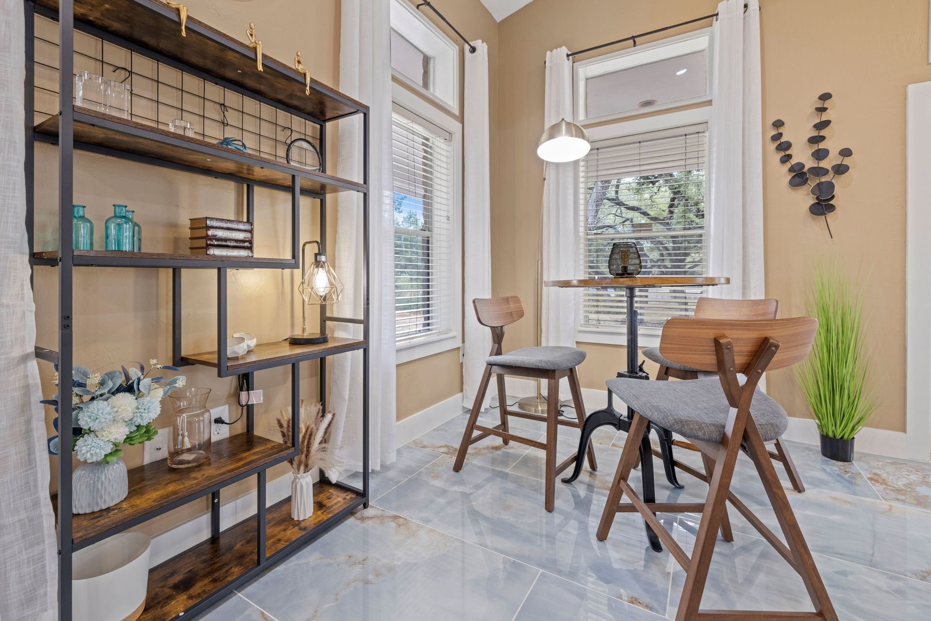 A living room with a table and chairs and a bookshelf at Allure at Shavano.