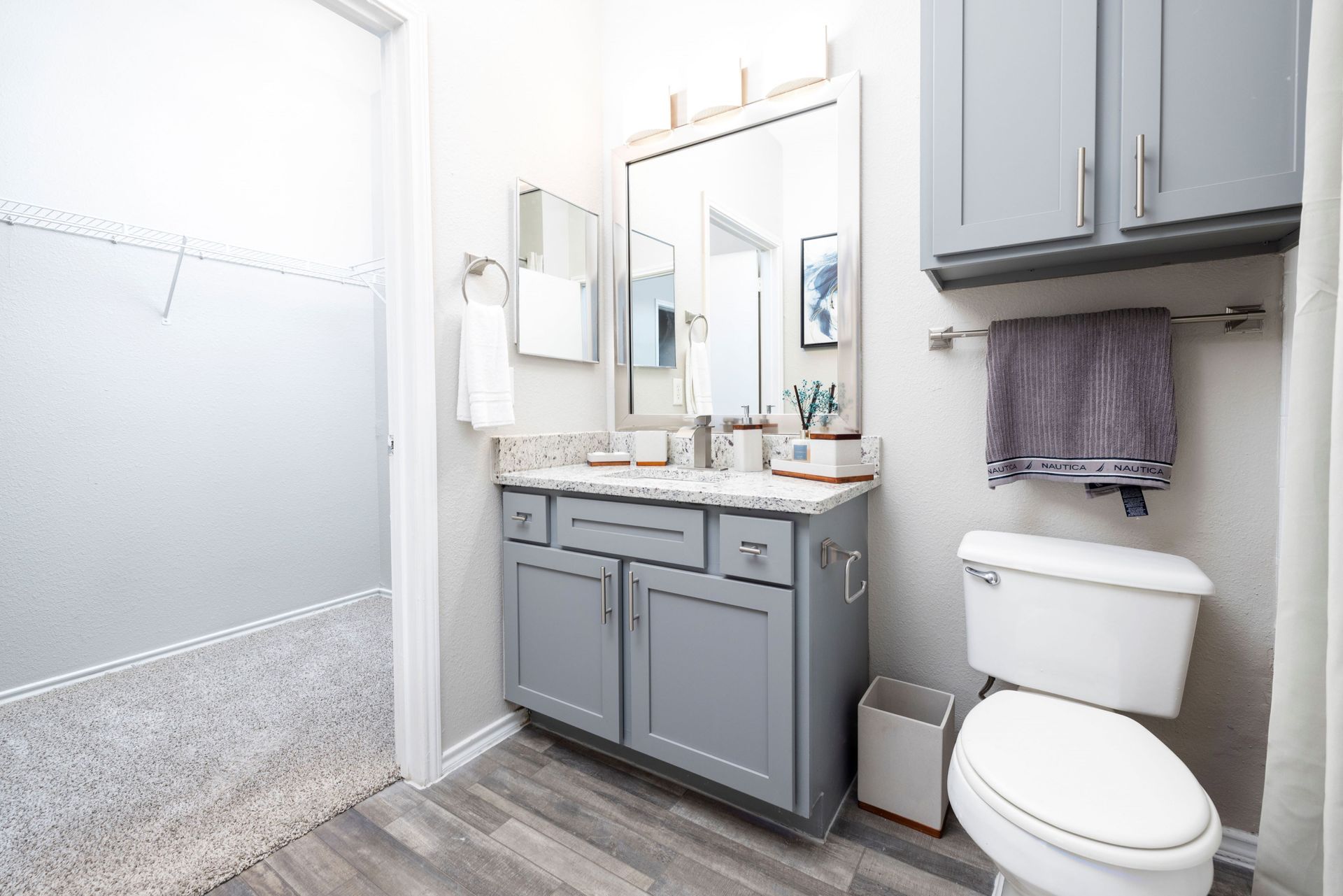 A bathroom with a toilet , sink and mirror at Allure at Shavano.
