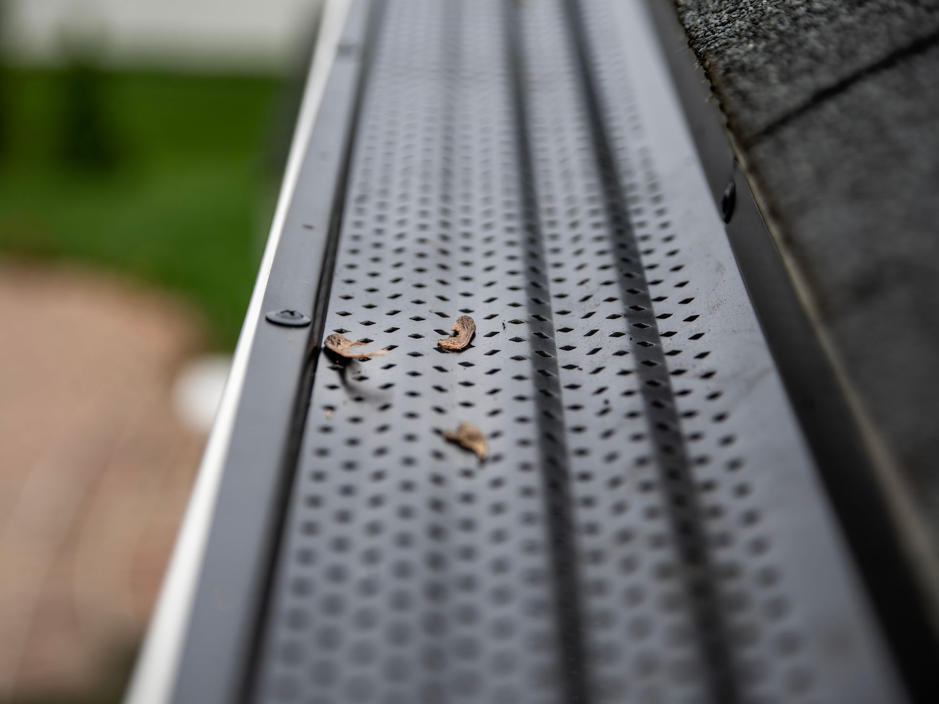 A close up of a gutter with leaves on it.