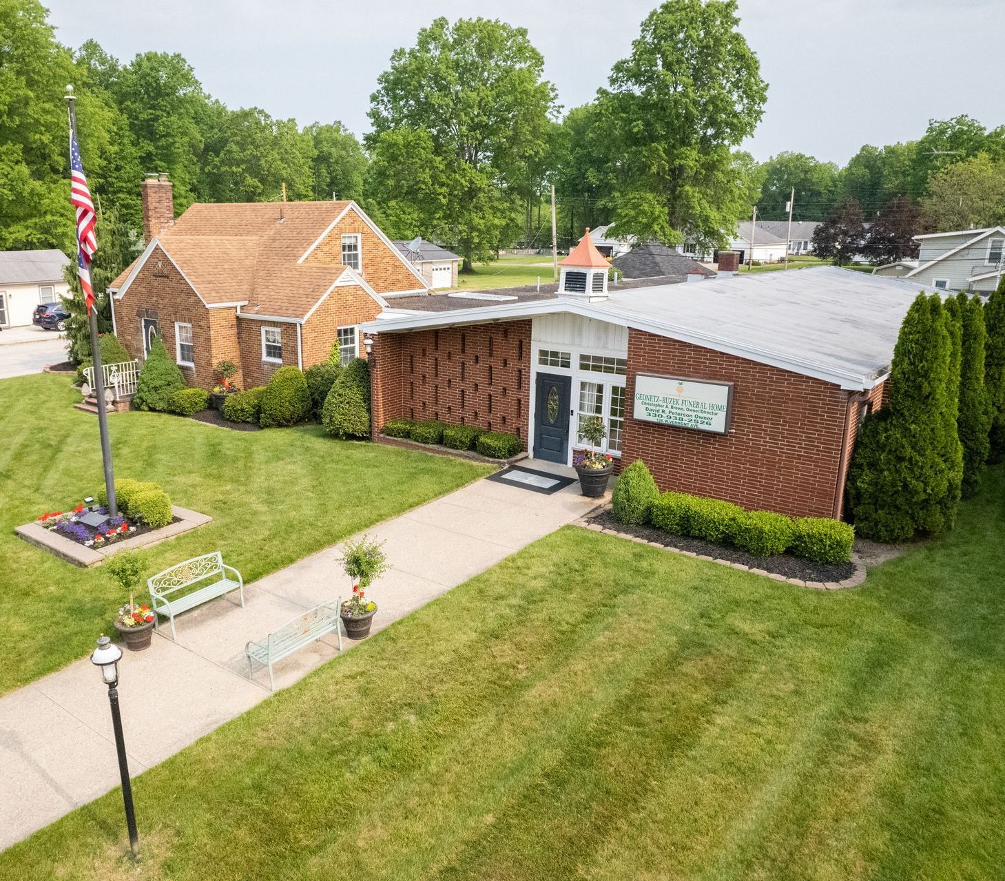 An aerial view of a brick house with a flag in front of it