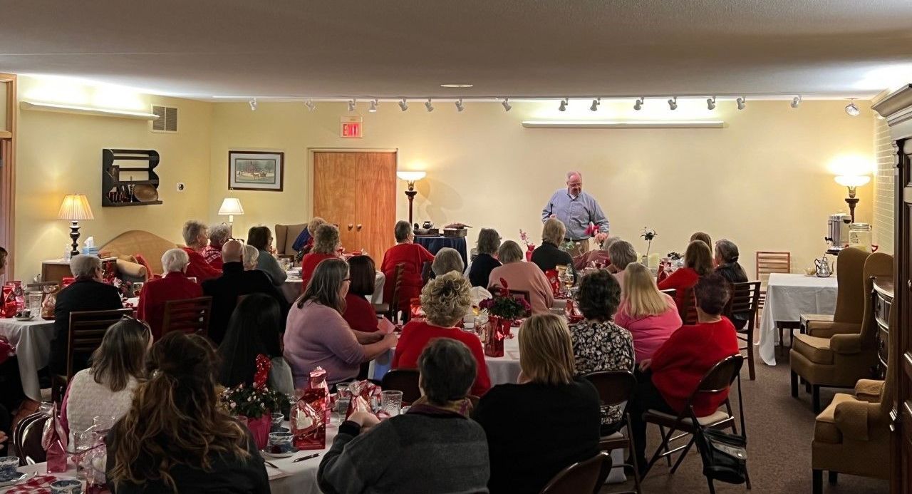 A large group of people are sitting at tables in a room.