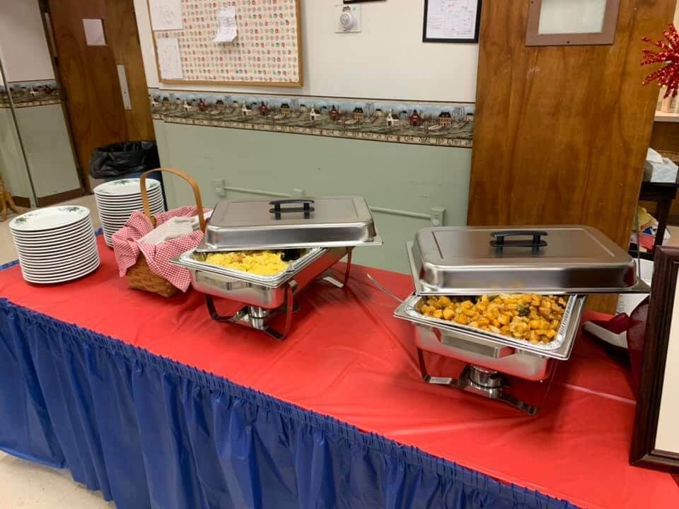 A buffet table with three trays of food on it.