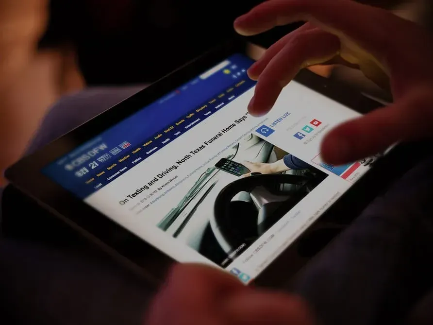 A person is using a tablet to read a news article