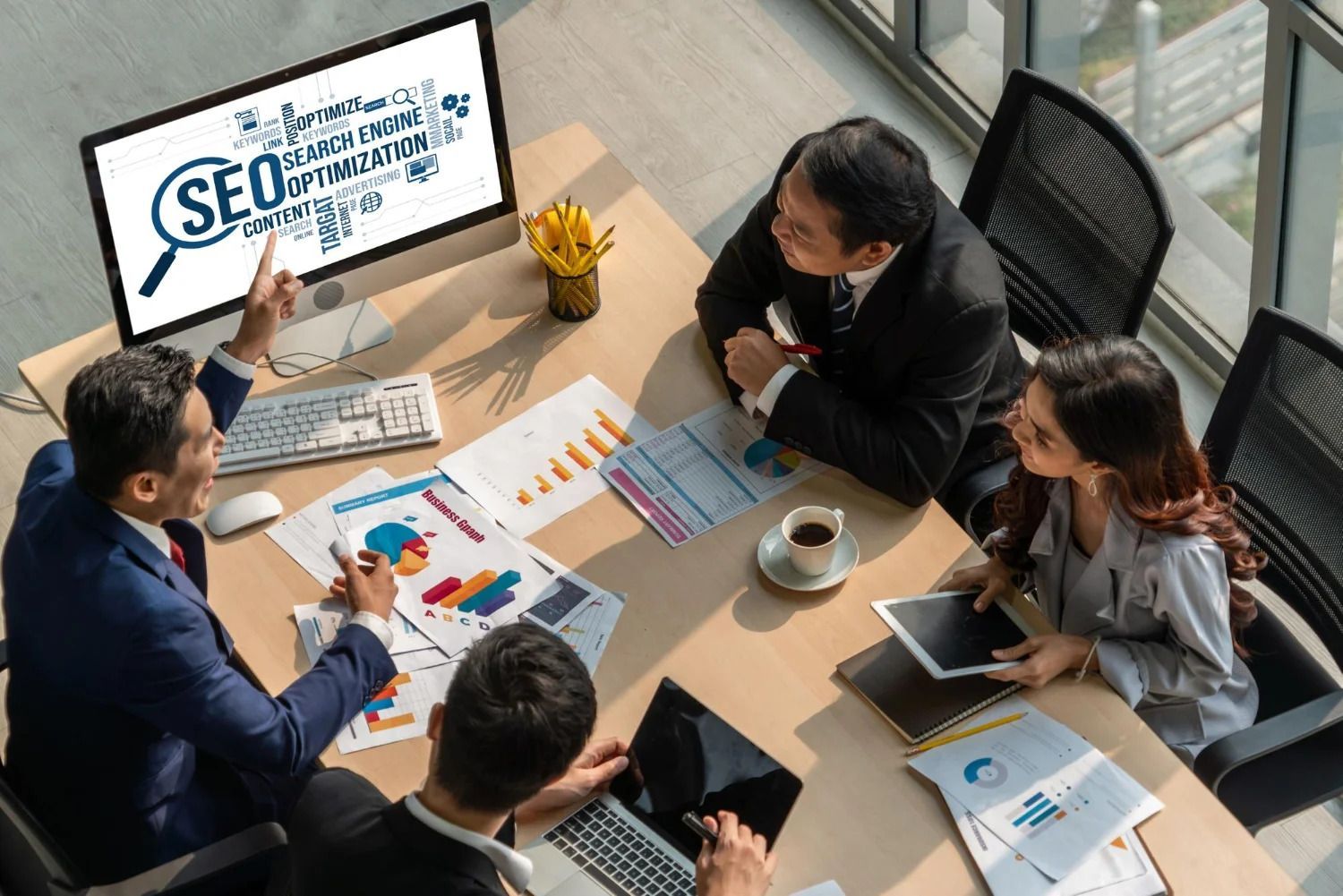A group of people are sitting around a table looking at a computer screen.