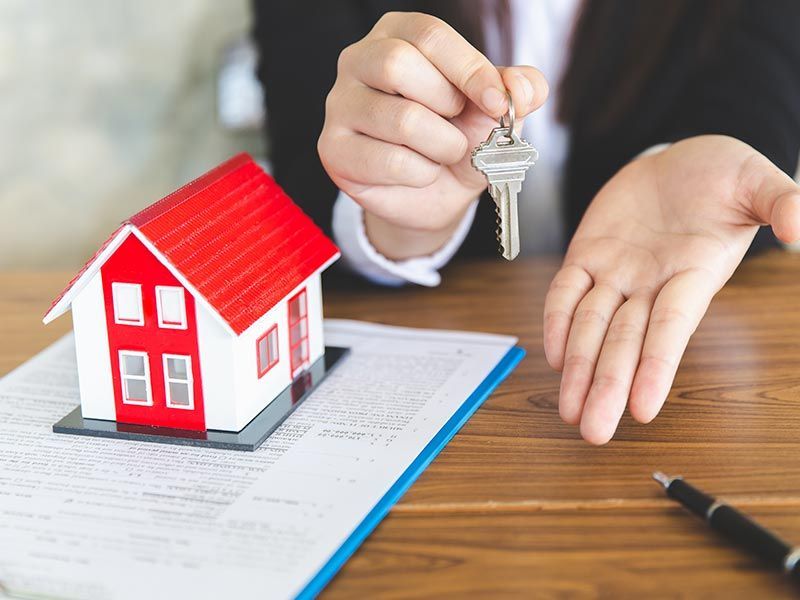 New House, Real Estate Agent Holding House Key to His Client After Signing Contract Agreement in Off