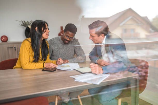 A couple in a meeting is checking documents with a closing professional