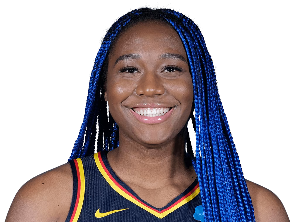 Aliyah Boston with blue braids is smiling for the camera