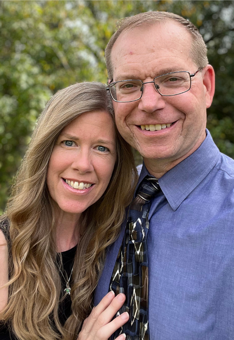 Lisa and Andy Renshaw pose together happily smiling.